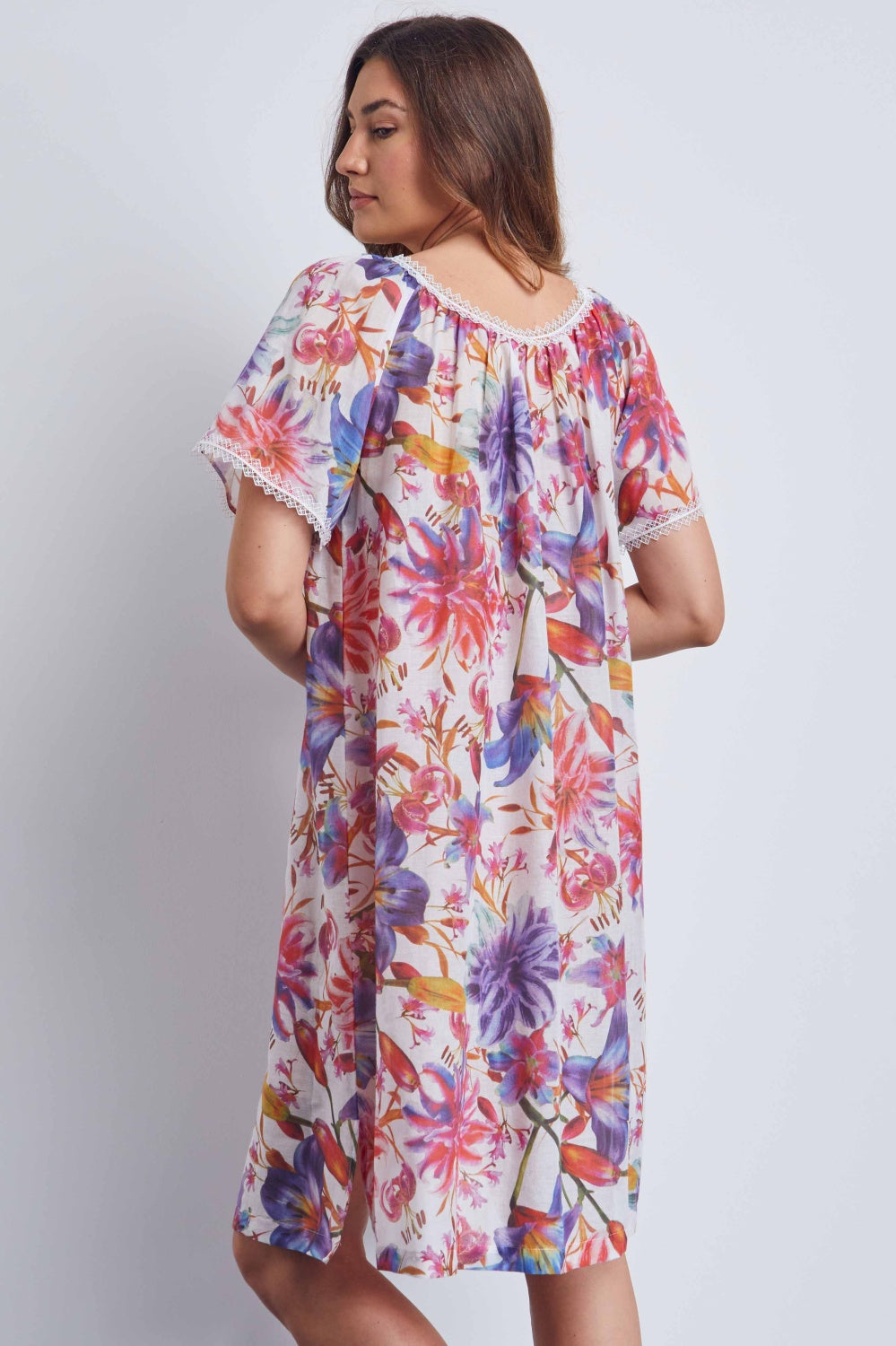 White floral print lounger with vibrant pink, purple, orange, blue flowers. Gathered round neck, cap sleeves with white lace