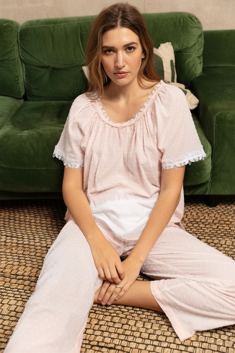 Pale pink SwissDot pajama set with a short-sleeve top featuring a gathered neckline and sleeve cuffs trimmed with white lace,
