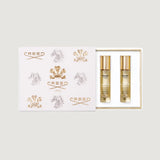 White gift box with embossed gold-toned and silver-toned Creed logos. Contains two clear perfume bottles with gold-toned caps