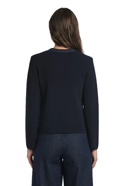 Dark blue knit cardigan, back view. Textured body, long sleeves, and a subtle contrasting dark blue trim at the collarless ne