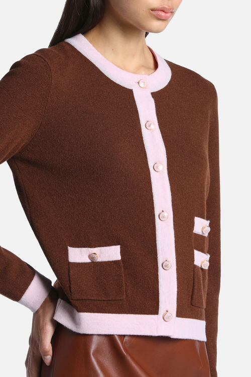 Chestnut brown cardigan with pink trim details. Heart-detailed pink buttons with gold-toned detail, two patch pockets.