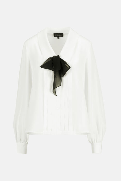 Off-white crêpe de Chine shirt with a V-neck, black sheer bow, vertical pintucks on the front, and long cuffed sleeves.