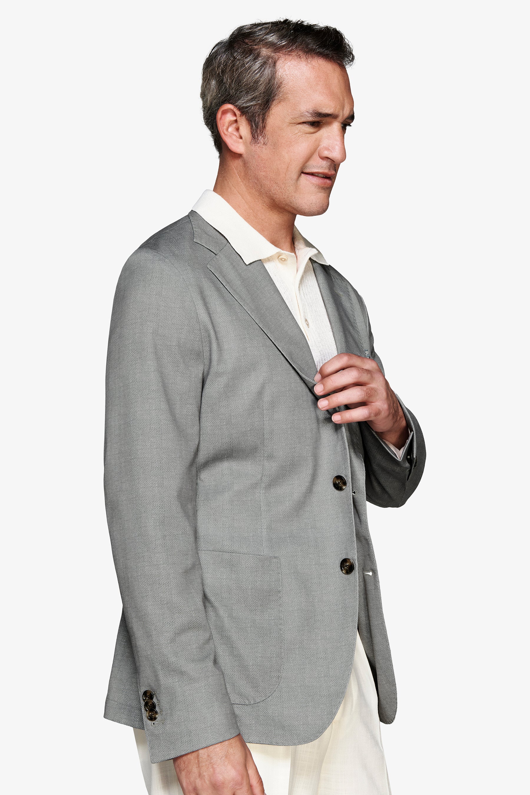 Sage green single-breasted blazer with notched lapels, two dark brown front buttons, a rounded patch pocket, and three cuff b