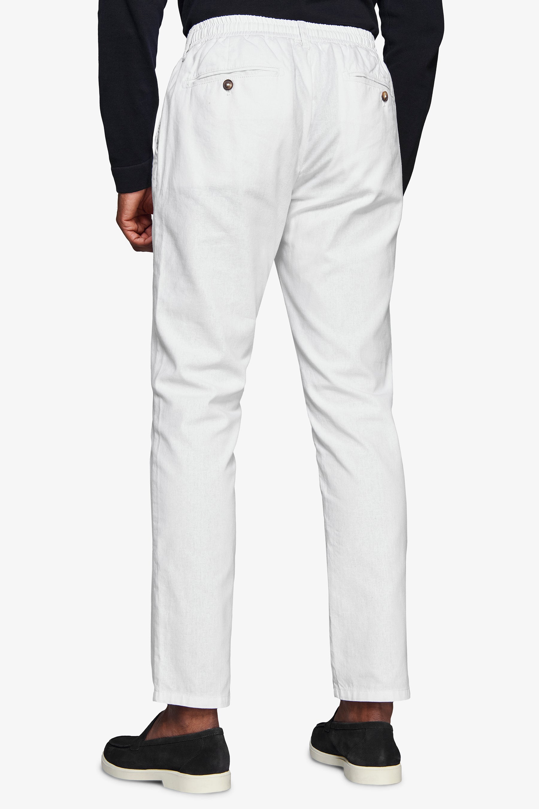 White trousers with an elasticated waistband and two back welt pockets, each with a brown button. Straight leg, lightweight f