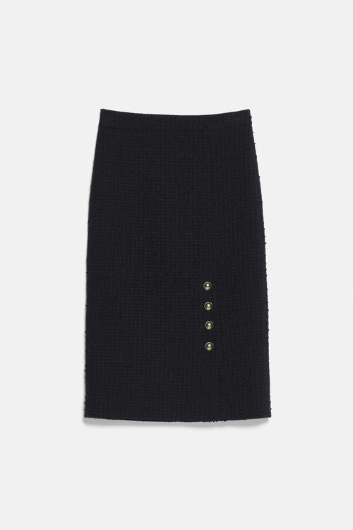 Black bouclé knit pencil skirt with four gold-toned buttons vertically aligned on the lower right. Raw hem.