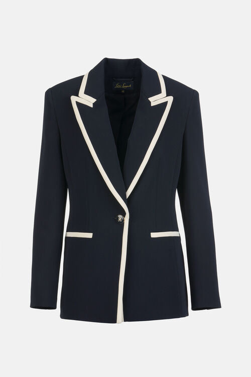 Navy blue blazer with off-white trim on notched lapels, single silver-toned button closure, and two off-white trimmed welt po