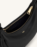 Black pebbled faux leather crossbody bag with a gold-toned zipper closure and "JW PEI" logo on the front and zipper pull.
