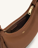 Brown textured faux leather crescent crossbody bag with gold-toned top zipper and 'JW PEI' logo. Dark brown interior lining.