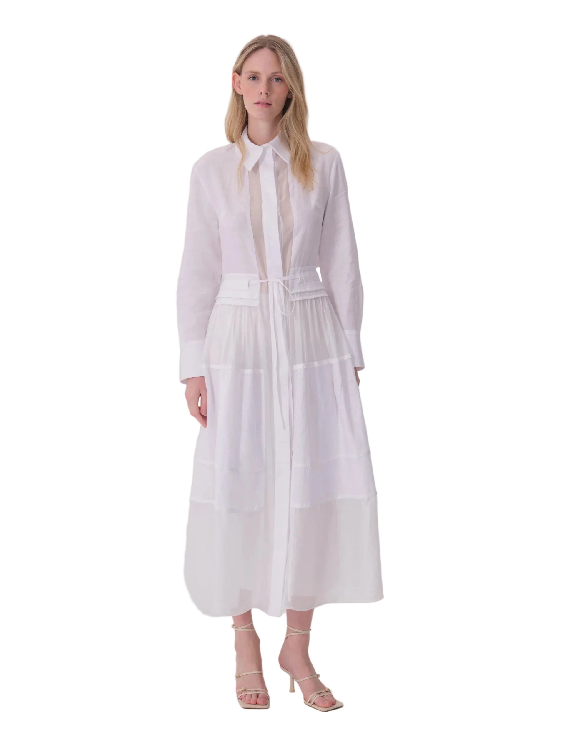 White long-sleeved collared shirt dress with a sheer upper panel, tie-fastening belt with flap pockets, and tiered skirt.