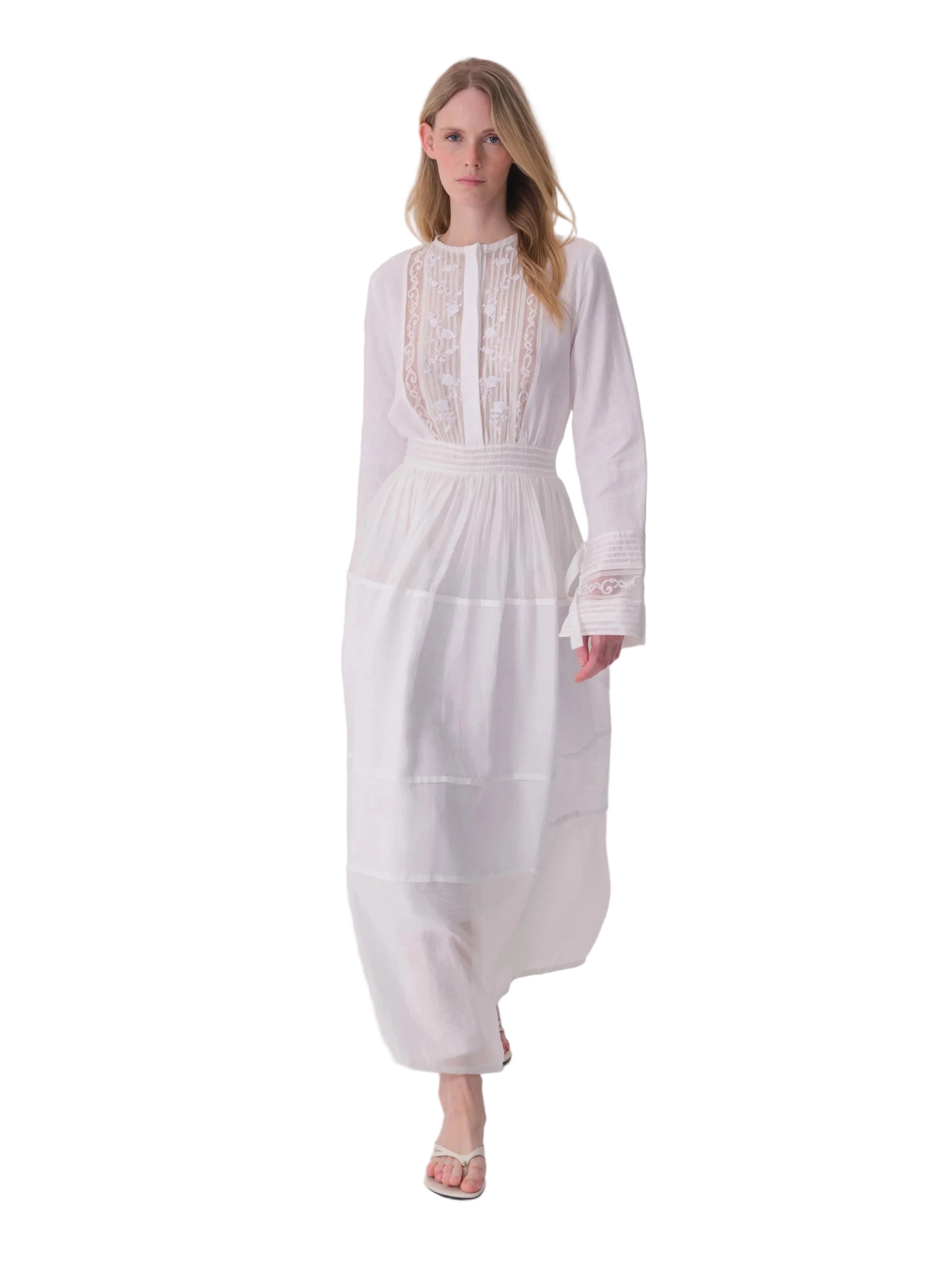White long-sleeved maxi dress with a high neckline, lace and pintuck bodice, shirred waist, and tiered skirt.