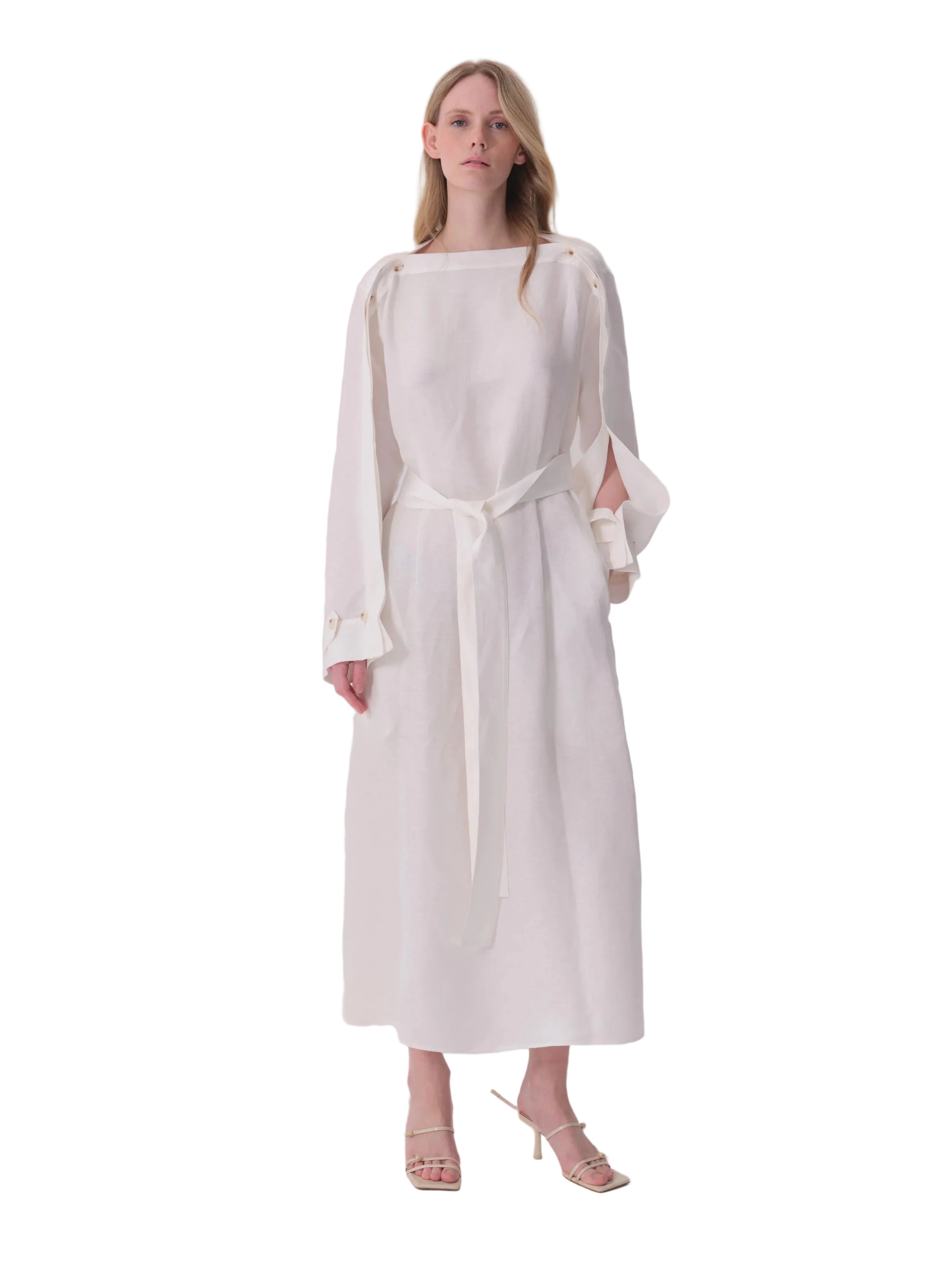 White flowing dress with boat neck, split long sleeves, self-tie belt, and gold-toned eyelet details