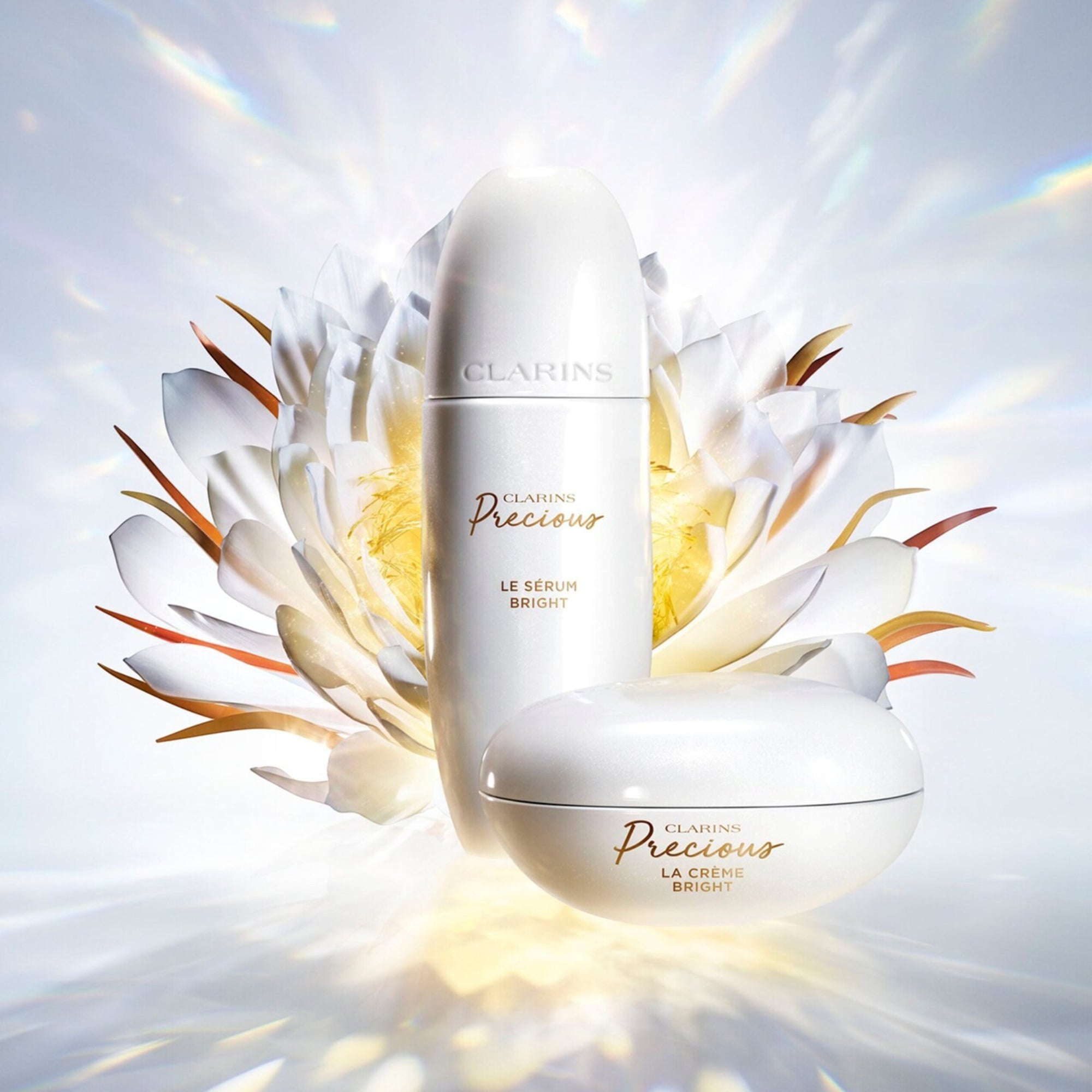 Tall, pearlescent white serum bottle with a rounded cap. It features 'CLARINS Precious LE SÉRUM BRIGHT' text, with 'Precious'