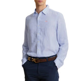 Light blue pinstriped long-sleeve button-up shirt with a collar, white buttons, and a small pink embroidered logo on the left