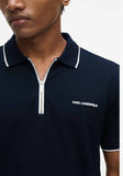 Navy blue polo shirt with white piping on collar and cuffs, silver-toned zipper placket, and white KARL LAGERFELD logo.