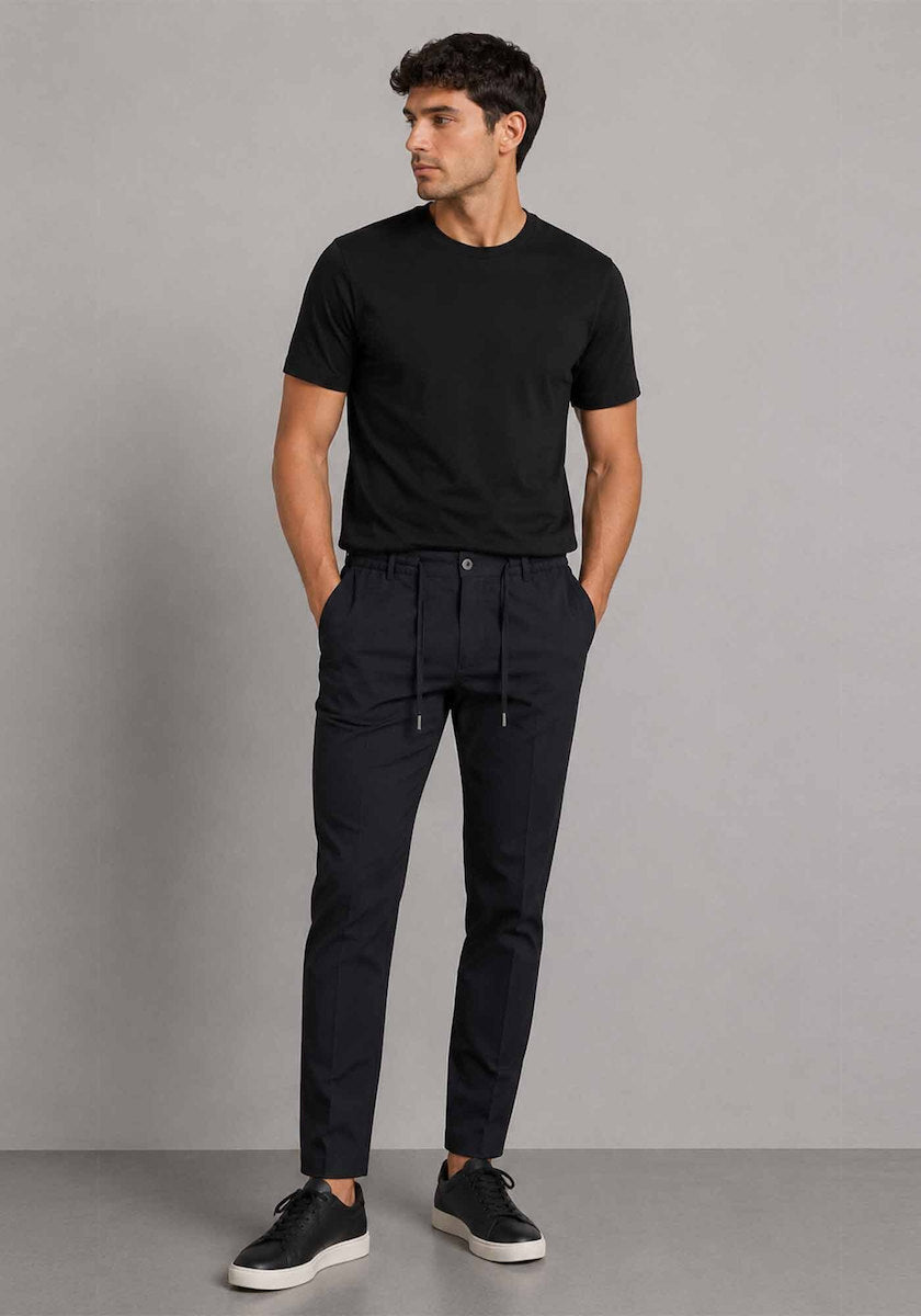 Midnight blue chino pants with an elasticated drawstring waist, single button closure, side pockets, and tapered legs with fr