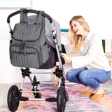 Grey quilted backpack with a flap closure, two front zippered pockets, side pockets, and adjustable shoulder straps.