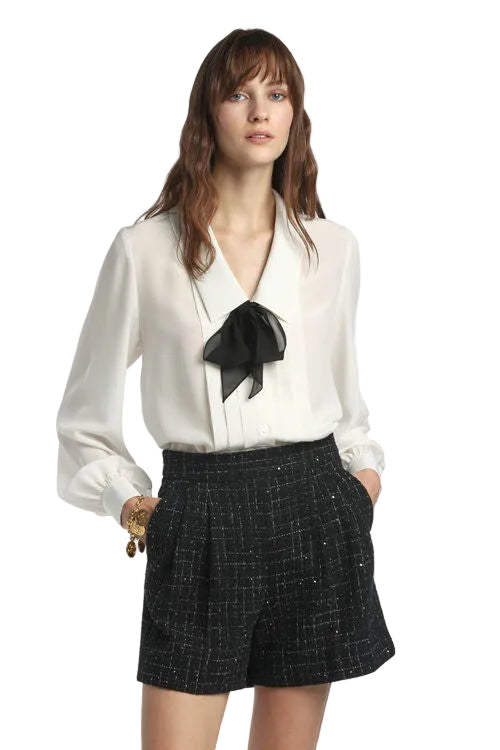 Off-white Crêpe de Chine blouse with a V-neck, pointed collar, long sleeves with gathered cuffs, and a black self-tie bow.