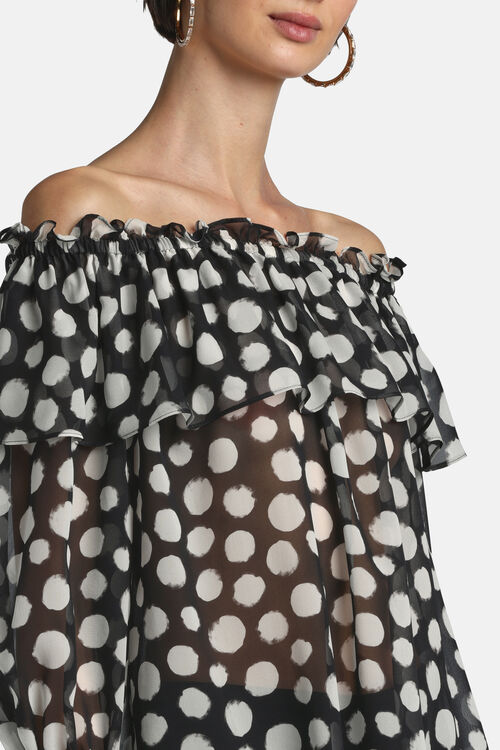 Sheer black off-shoulder blouse with irregular white polka dots, ruffled neckline, and tiered ruffle overlay.