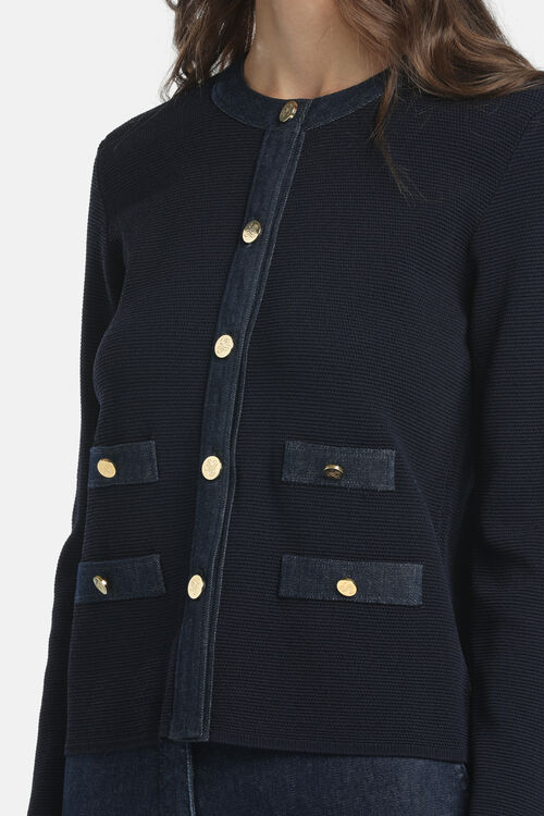 Dark blue knit cardigan with a round neck, denim front placket, and four denim patch pockets, all with gold-toned buttons.