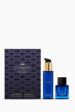 Thameen The Cora gift set with dark blue body lotion and extrait de parfum bottles, and a dark purple patterned box.
