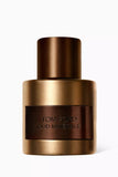 Tom Ford Signature Oud Minerale EDP spray bottle with a bronze-gold matte metallic finish and a dark brown recessed label.
