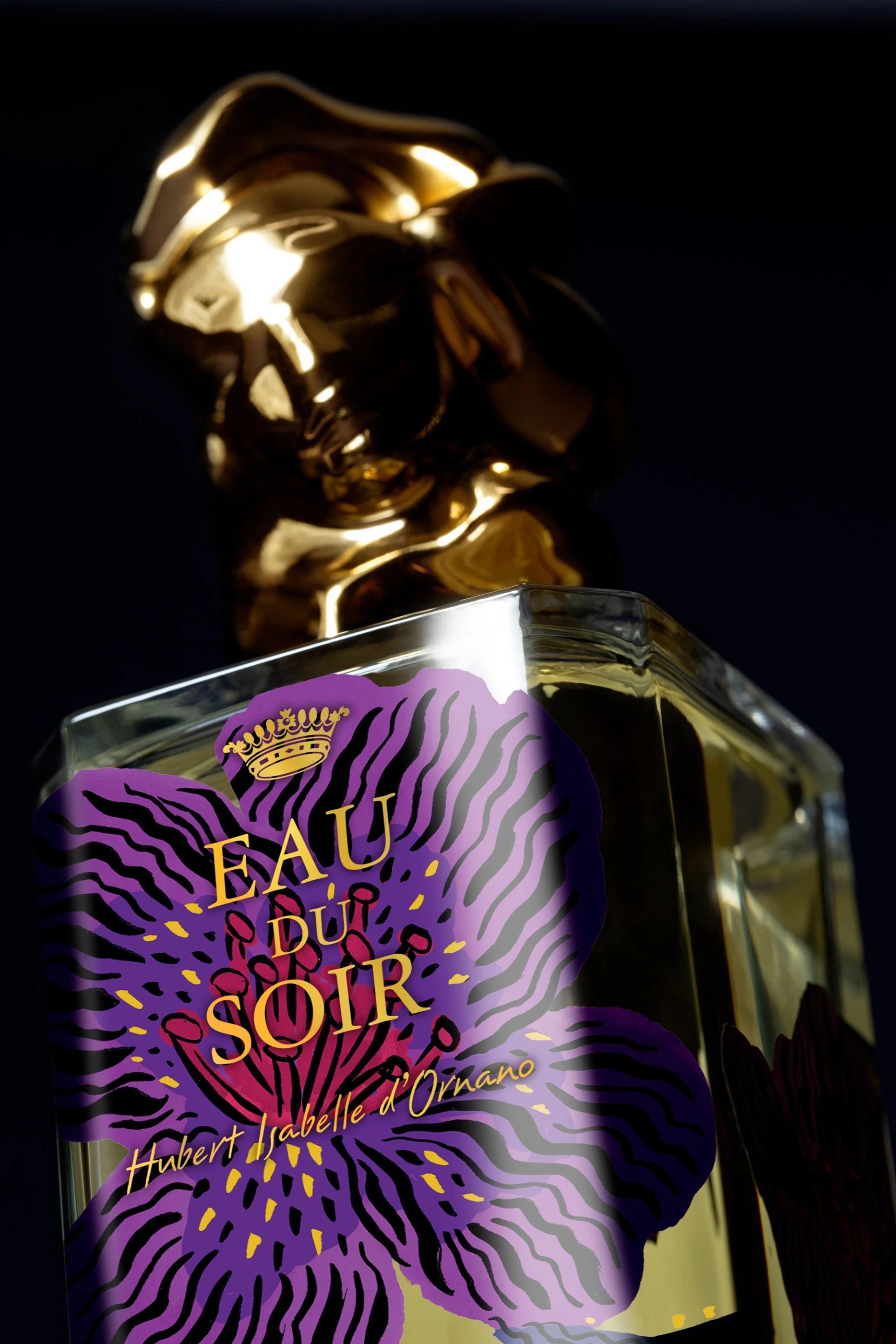 Clear rectangular perfume bottle with light yellow liquid, a purple floral label with black stripes and yellow dots, and a go
