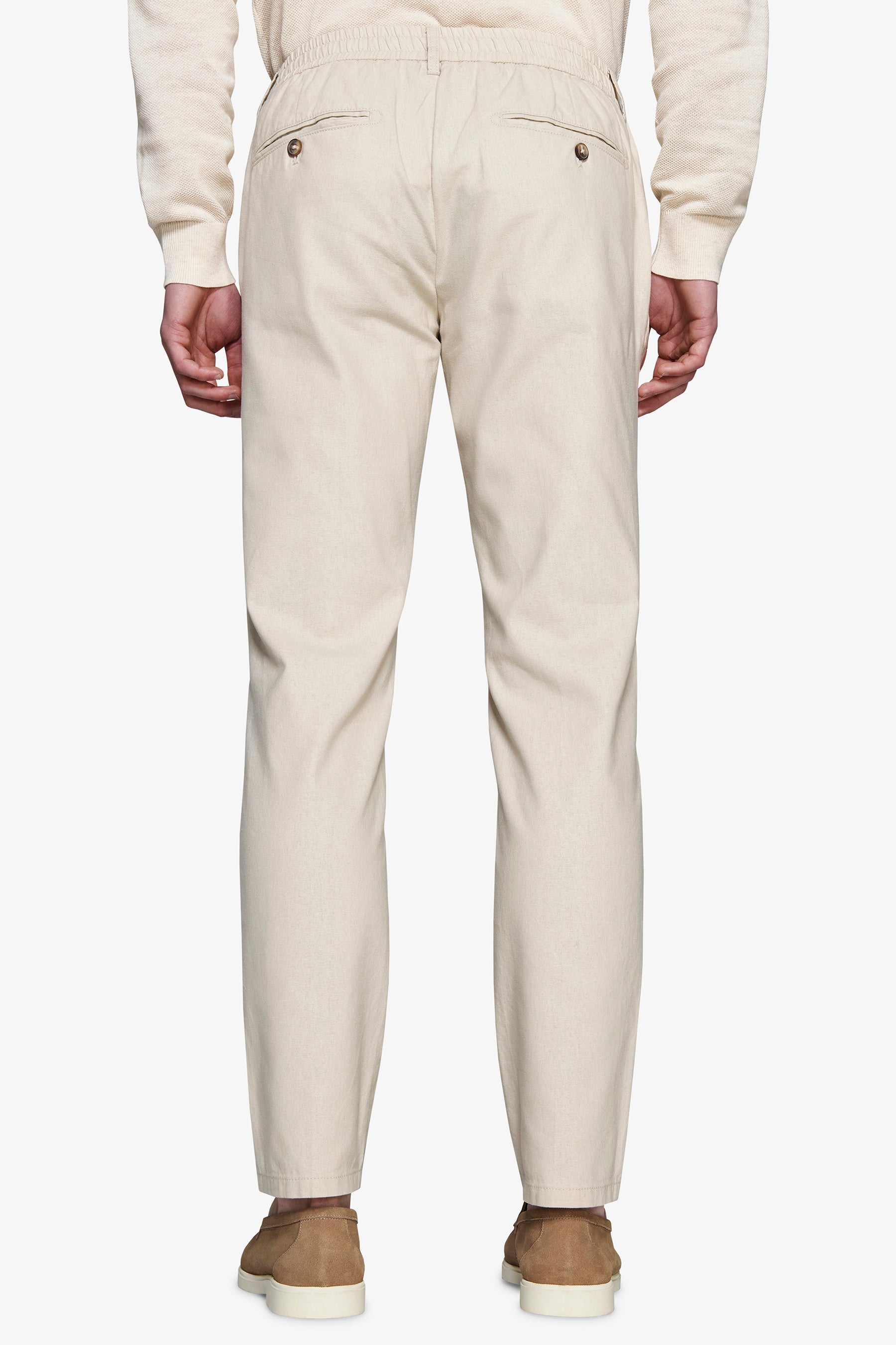 Light beige trousers with an elasticated back waist, two back welt pockets with brown buttons, and a straight-leg fit.