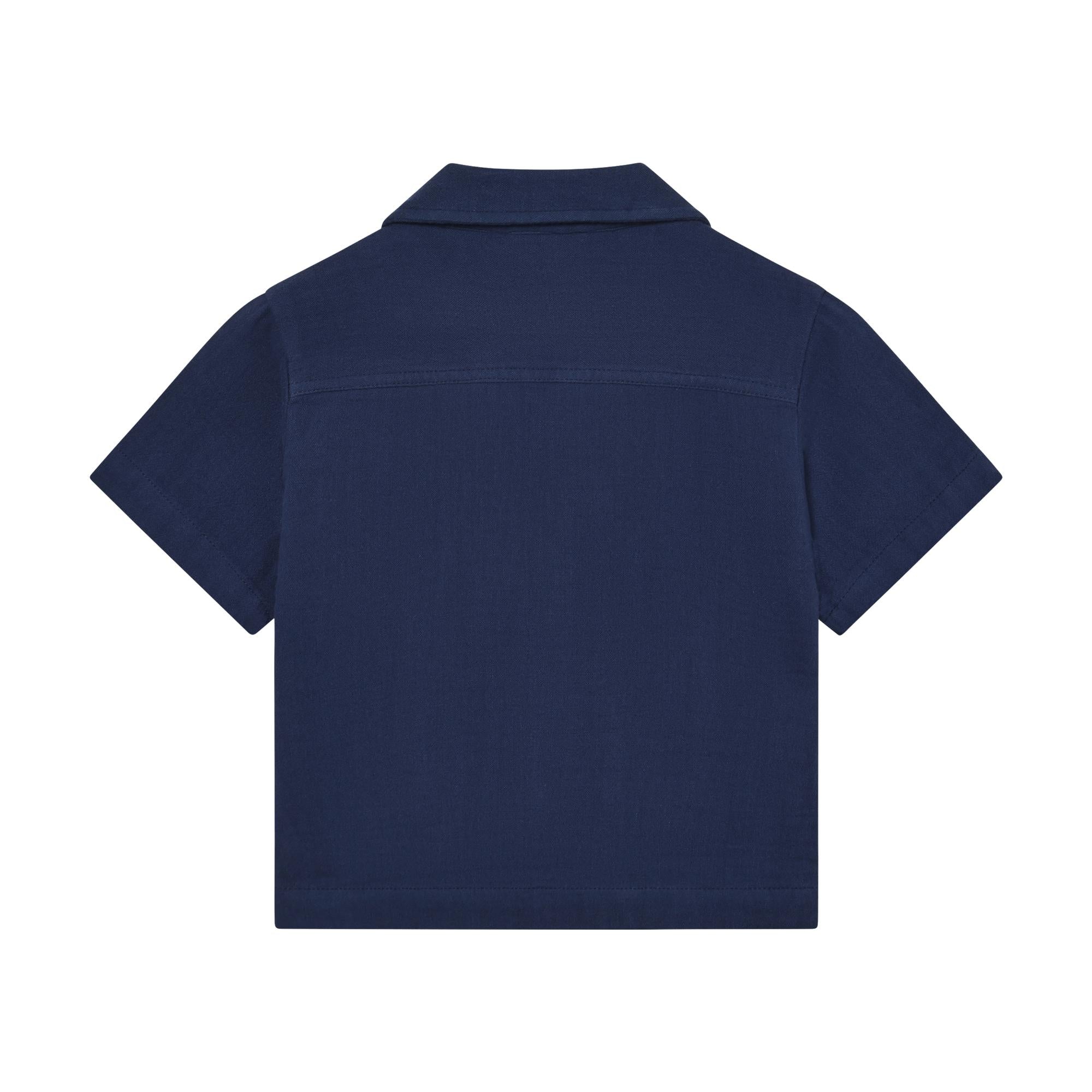 Muslin blue short-sleeve shirt, back view. Features a collar and a horizontal yoke seam across the upper back.