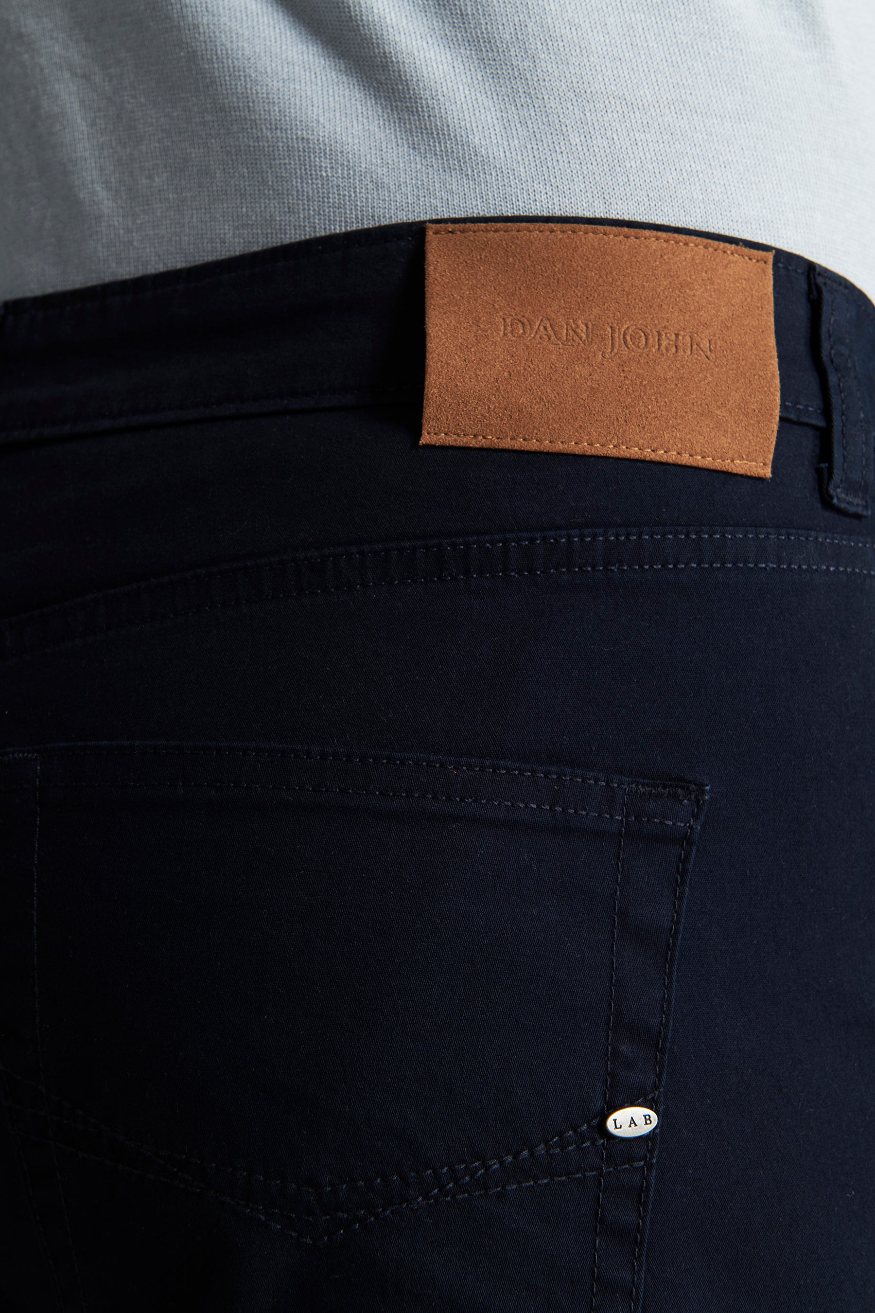 Navy straight-leg trousers with a brown DAN JOHN patch on the back waistband and a silver-toned LAB tag on the right back poc