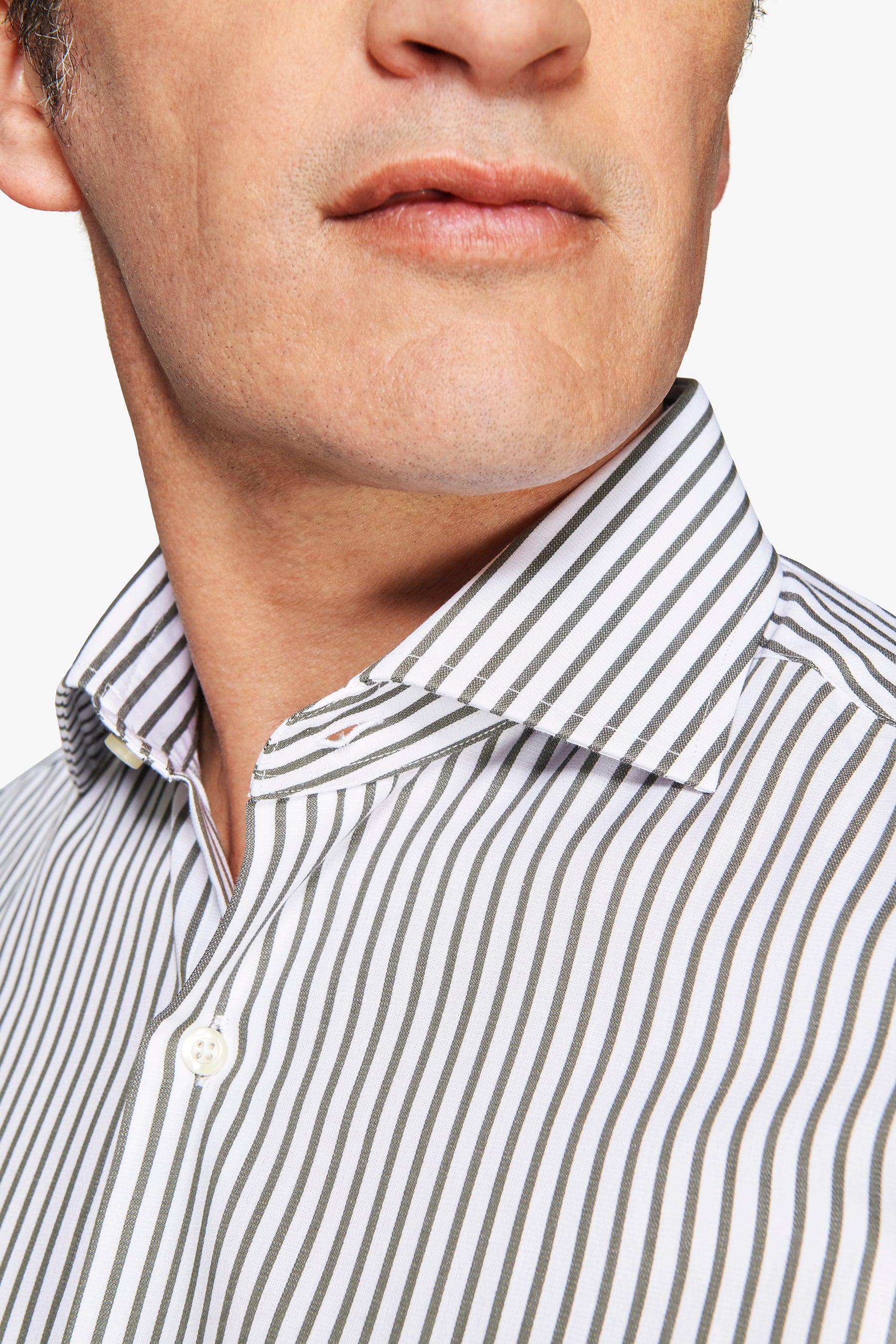 White shirt with thin vertical olive green stripes, a spread collar, and a visible white button on the placket.