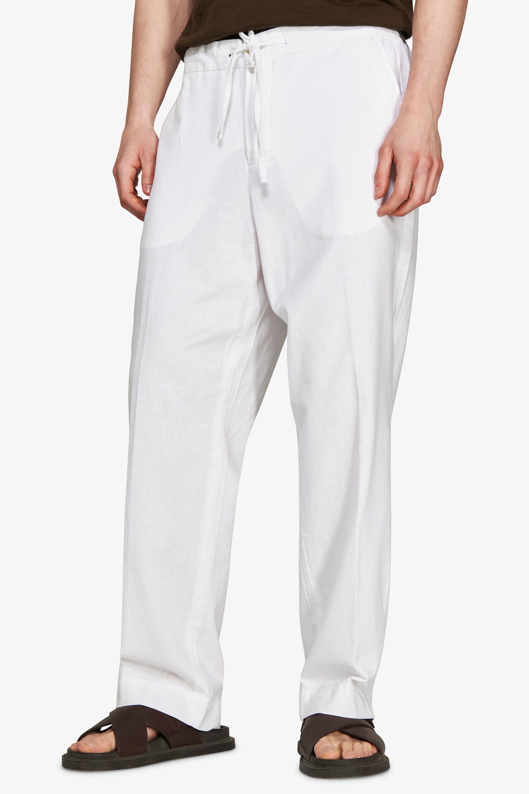 White relaxed fit linen blend trousers with an elasticated drawstring waist and side pockets.