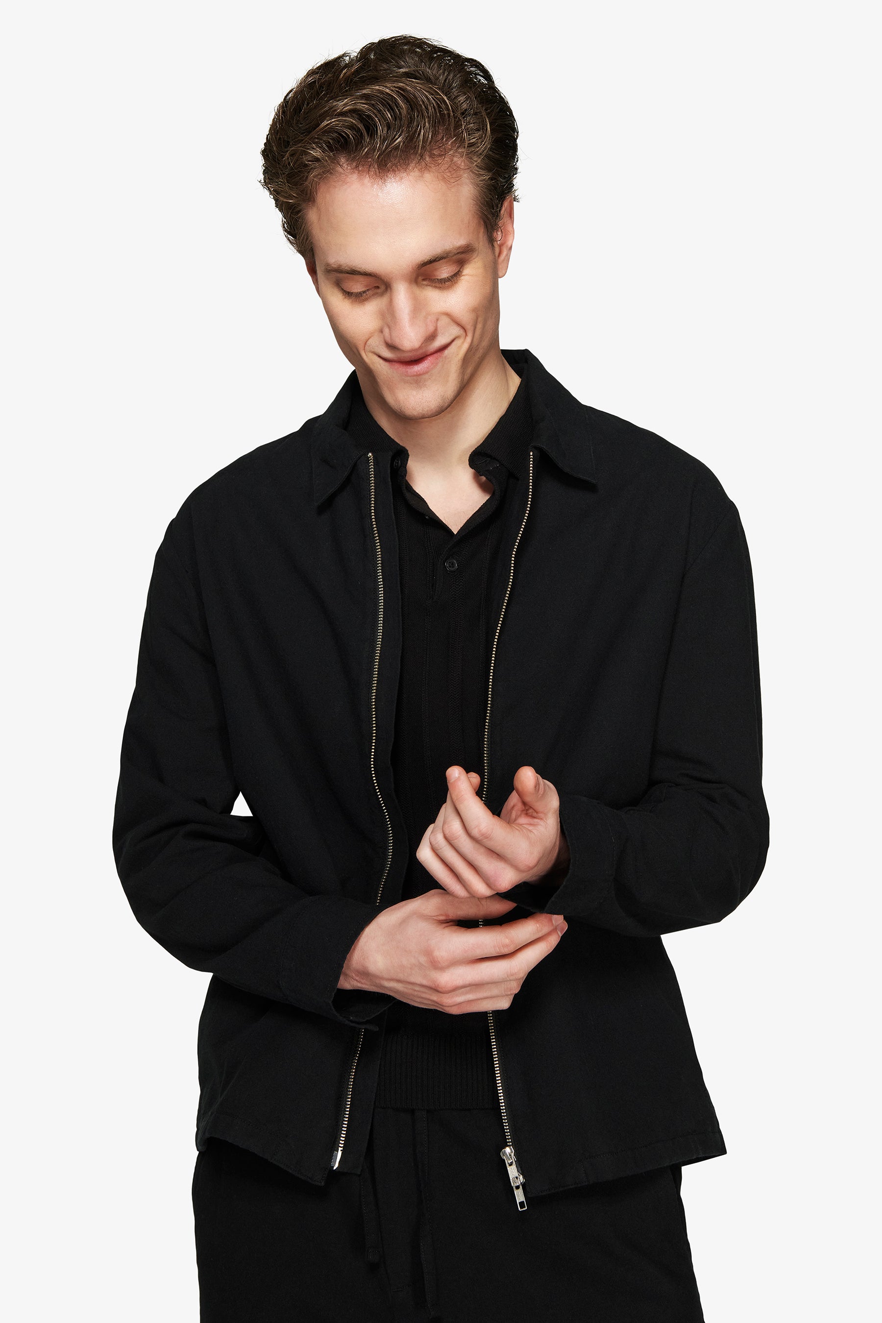 Black collared jacket with a full-length silver-toned zipper, long sleeves, and simple cuffs.