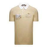 Khaki short-sleeve polo shirt with a white collar, two-button placket, and military-themed patches and gold-toned embroidery