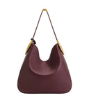 Burgundy smooth hobo bag with a single thin strap and gold-toned, curved metal hardware connecting the strap to the bag.
