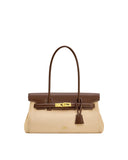Beige shoulder bag with dark brown top flap, trim, and thin straps. Features a gold-toned clasp, white contrast stitching, an