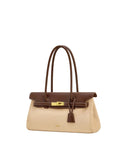 Two-tone shoulder bag with a light beige body, dark brown flap, top handles, and trim. Gold-toned turn-lock closure and contr