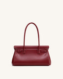 Dark red structured shoulder bag with two thin top handles, a top flap closure, and white contrast stitching.