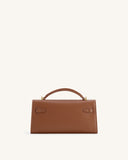 Structured brown top handle bag with textured finish, a single top handle, and two decorative strap details with gold-toned b