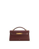 Deep burgundy top handle bag with a front flap, gold-toned turn-lock clasp, and white contrast stitching.