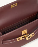Deep burgundy faux leather bag with white contrast stitching and a gold-toned turn-lock closure. Interior shows a small slot.