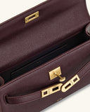 Deep burgundy pebbled faux leather top handle bag with an open flap, gold-toned turn-lock closure, and rectangular hardware.