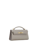 Grey textured top handle bag with a flap closure, gold-toned turn-lock clasp, and a single top handle.