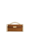 Brown suede-like structured top handbag with cream faux shearling trim on handle and sides. Features a brown strap and gold-t