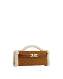 Brown faux suede structured handbag with cream fluffy trim and top handle, featuring a brown strap and gold-toned turn-lock c