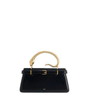 Black structured top handle bag with a gold-toned snake handle featuring green eyes and a front buckle detail