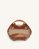 Brown pebbled tote bag with two top handles, soft bow drawstring closure, gold-toned hardware, and a light interior.