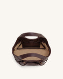 Dark brown pebbled leather soft tote bag with two top handles, drawstring closure forming front bows, light tan interior, and