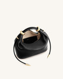 Black pebbled top handle bag with gold-toned metal rings, zipper, and drawstring tips. Light interior with a black card holde