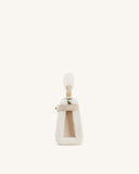 Cream faux shearling top handle bag with light beige faux suede trim, handle, and interior lining, featuring a gold-toned cla