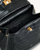 Black crocodile-embossed faux leather top handle bag with gold-toned turn-lock closure and hardware. Open, showing black inte